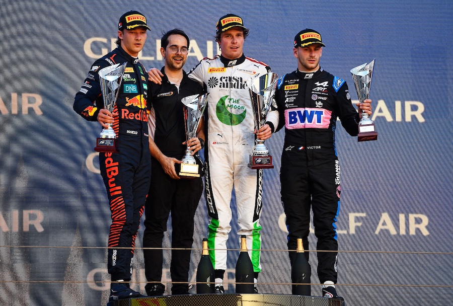 Ralph Boschung, Dennis Hauger et Victor Martins sur le podium de la course sprint FIA F2 2023 à Bahrein, avec leur trophée à la main.