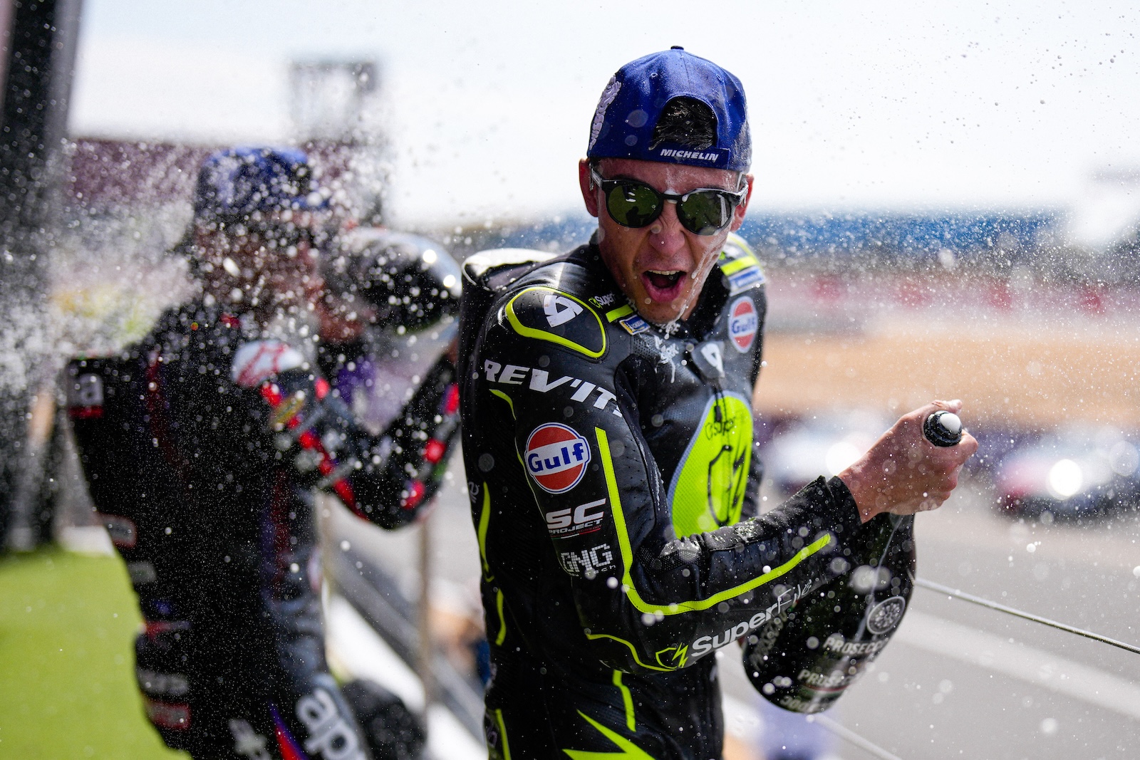 Raul Fernandez avec une bouteille de champagne sur le podium